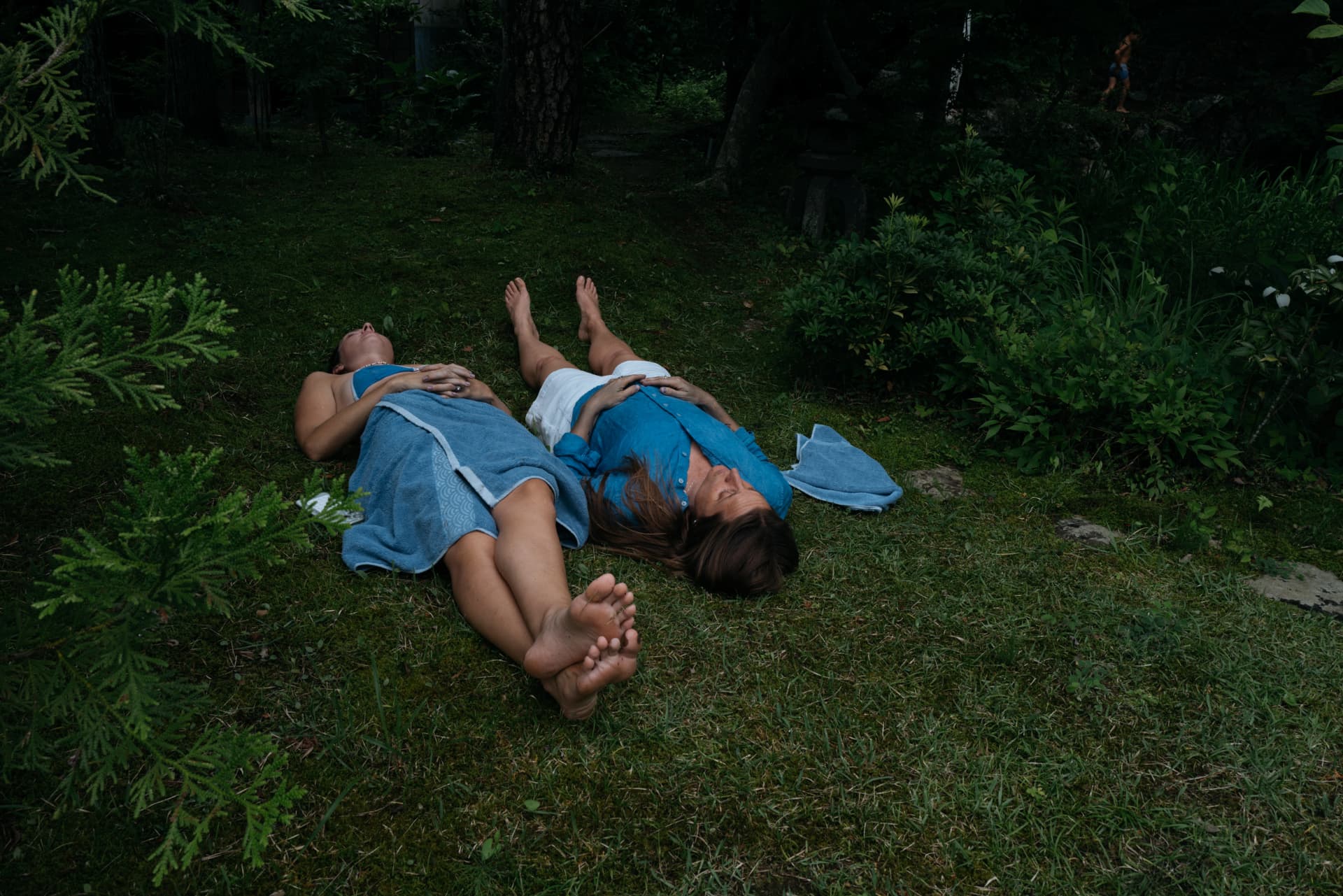 Two people relaxing outdoors wrapped in Aizome towels